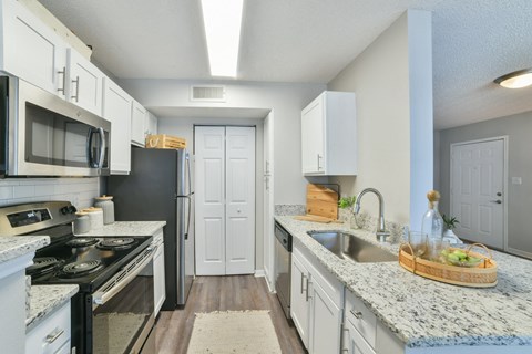 a kitchen with white cabinets and black and white appliances